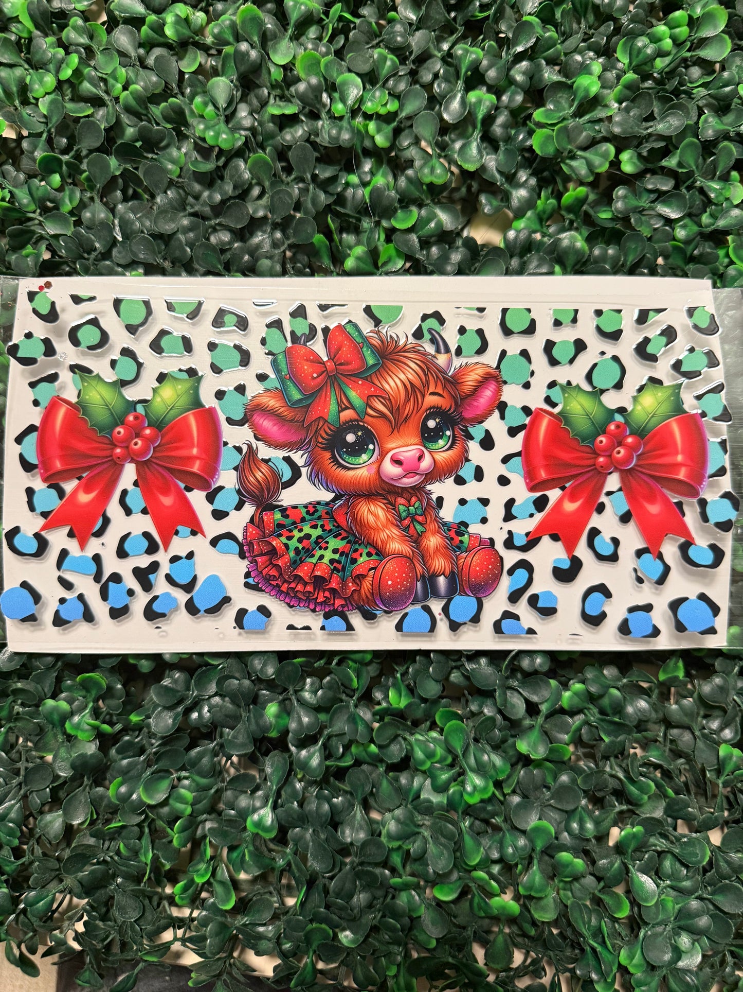 Blue and green cheetah print cow with a holly bow